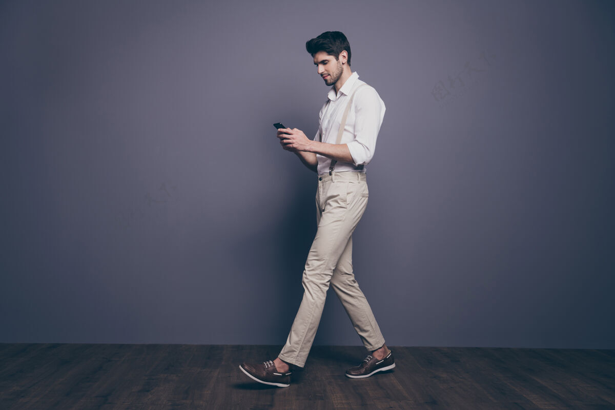 年轻全尺寸侧面肖像集中的家伙走路去复印空间用智能手机聊天和同事穿好看的衣服Steps男士商务人士