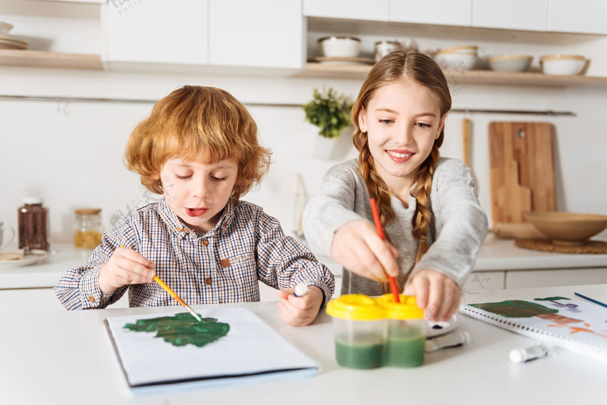 人才我们该怎么办下一个令人钦佩热情明亮的孩子们在一起度过周末 坐在厨房的桌子旁 享受着绘画的乐趣发展休闲水彩画