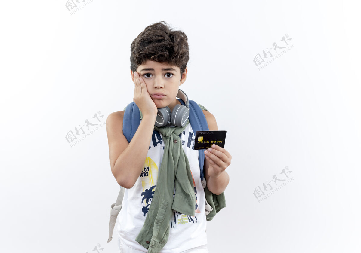 手可怜的小男孩 背着书包 戴着耳机 手放在脸颊上耳机背景背