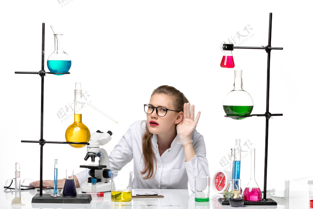 实验室前视图穿着白色医疗服的女医生坐在解决方案和试图听到白色背景上的健康化学大流行的柯维德女医生科学白色