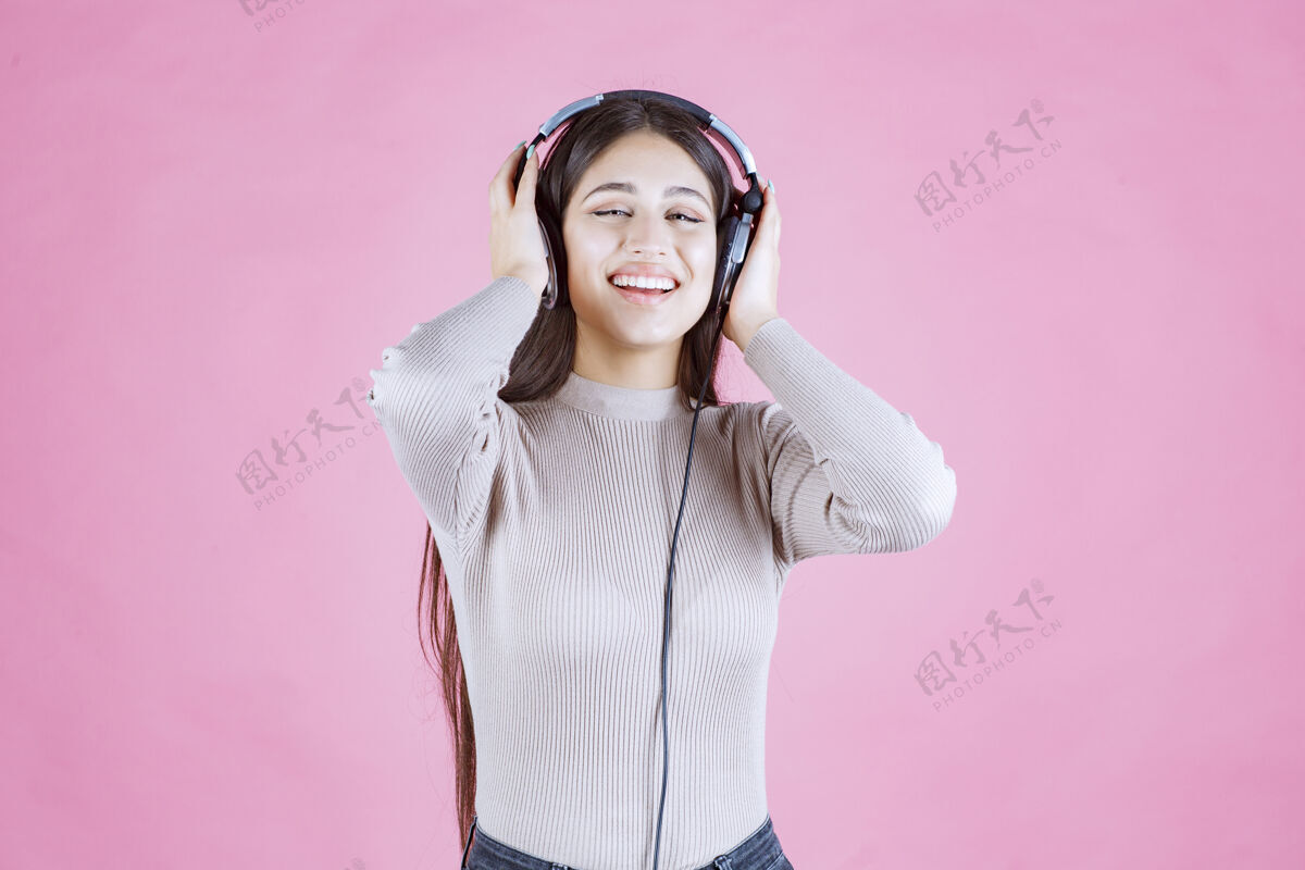 休闲戴着耳机的女孩听着音乐 感觉很开心迪斯科派对人类