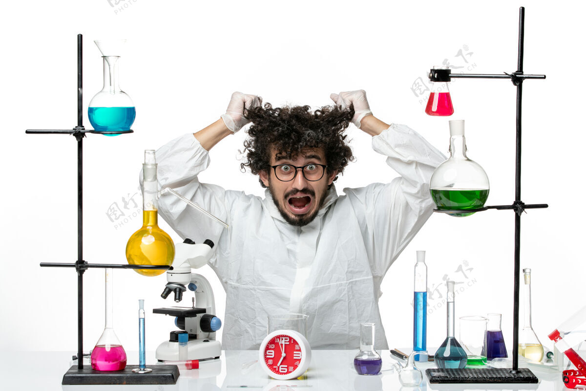 眼泪正面图：年轻的男科学家穿着白色的特殊套装 正在撕扯他的头发实验室科学家化学