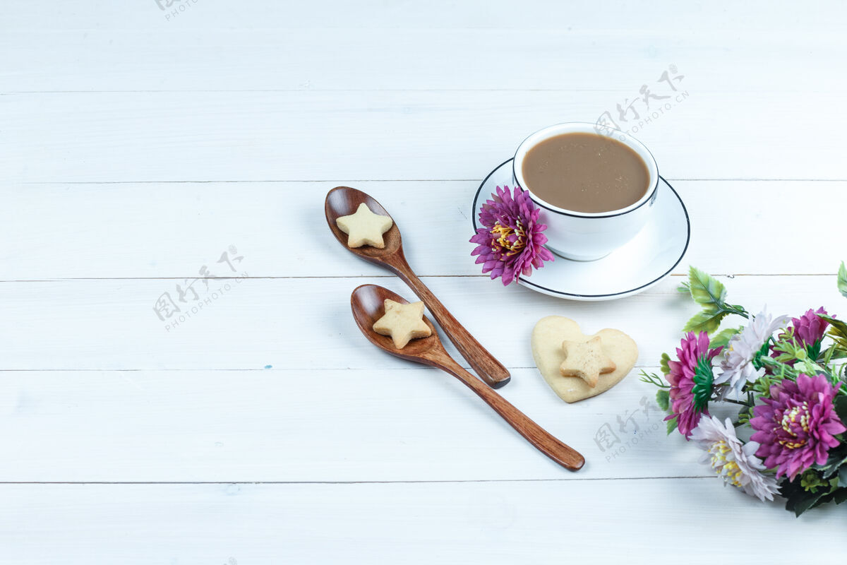 巧克力一套花 饼干在木制勺子和咖啡杯 心形和星星饼干在白色木板背景高角度视图水平高小吃