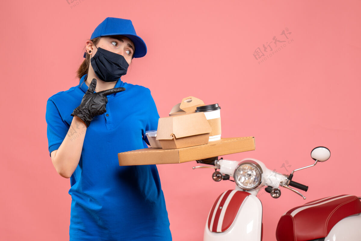 工人正面图：戴着面具的女快递员在粉色地板上送咖啡和食物-制服工作服务人员送货地板保护封面食品