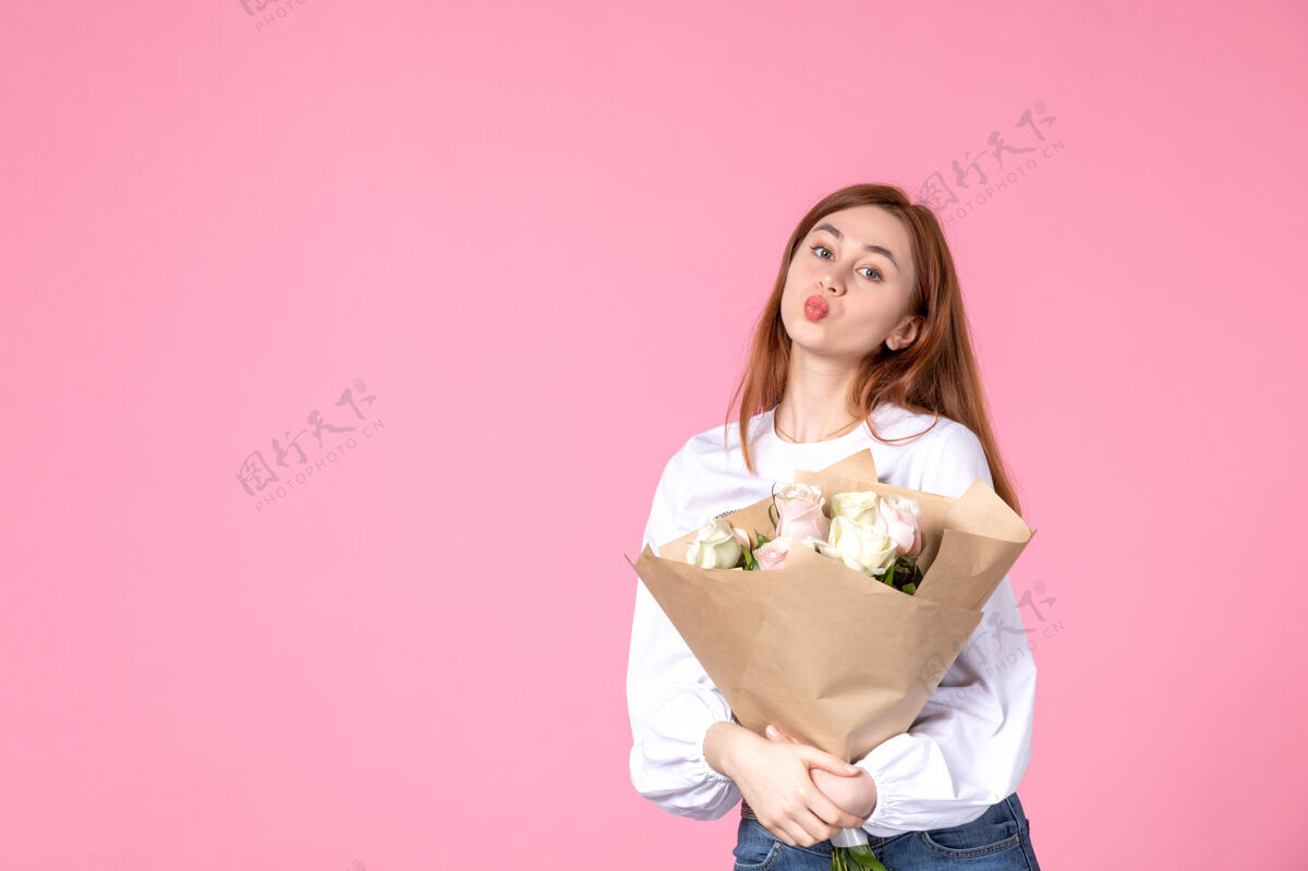 人正面图：带花的年轻女性作为女性节礼物 粉色背景水平女性三月女性约会平等玫瑰爱情花玫瑰花束