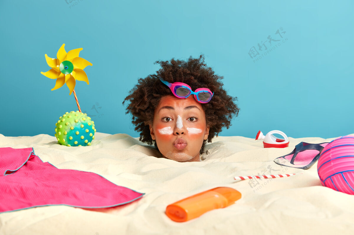 太阳年轻女子头上涂着防晒霜 脸上围着沙滩饰品海边头奶油