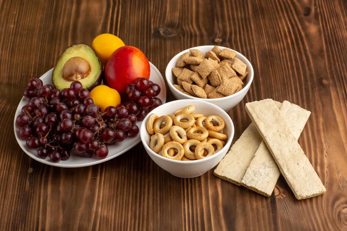 胡椒在棕色的木制书桌上可以看到不同的水果和饼干膳食健康饼干