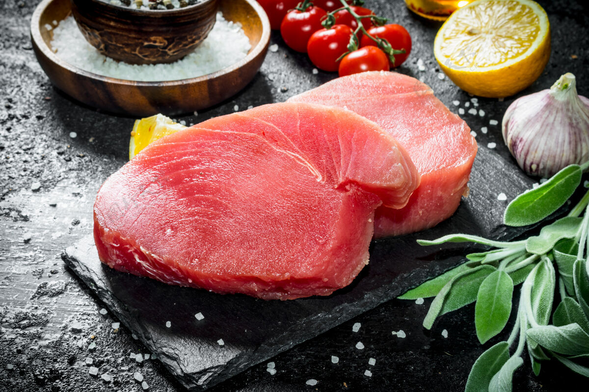 番茄生金枪鱼鱼片放在石板上 鼠尾草和柠檬放在乡村的桌子上香料日本部分