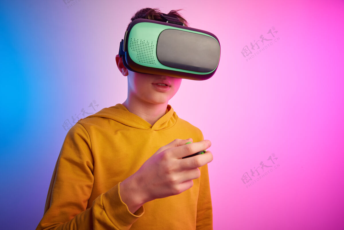男孩彩色墙上戴着虚拟现实眼镜的男孩未来科技 虚拟现实概念显示虚拟3d