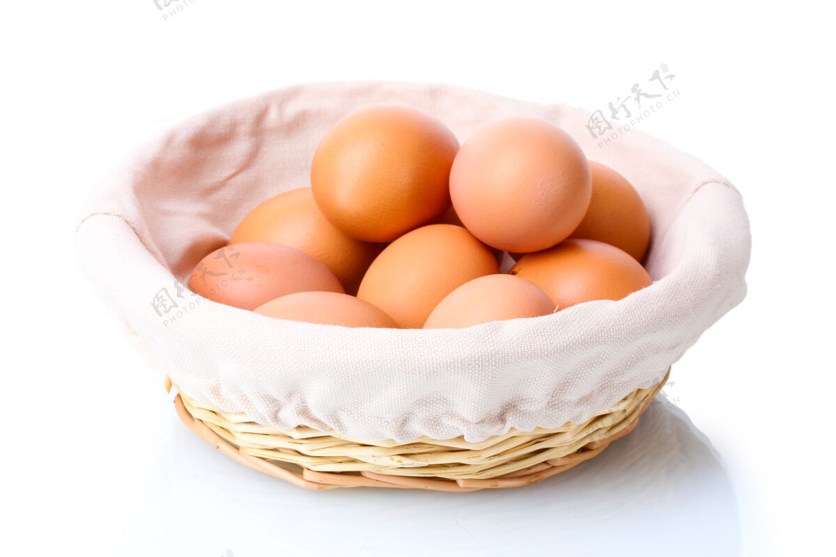 特写棕色的鸡蛋在篮子里隔离在白色的上面美食盒子农场