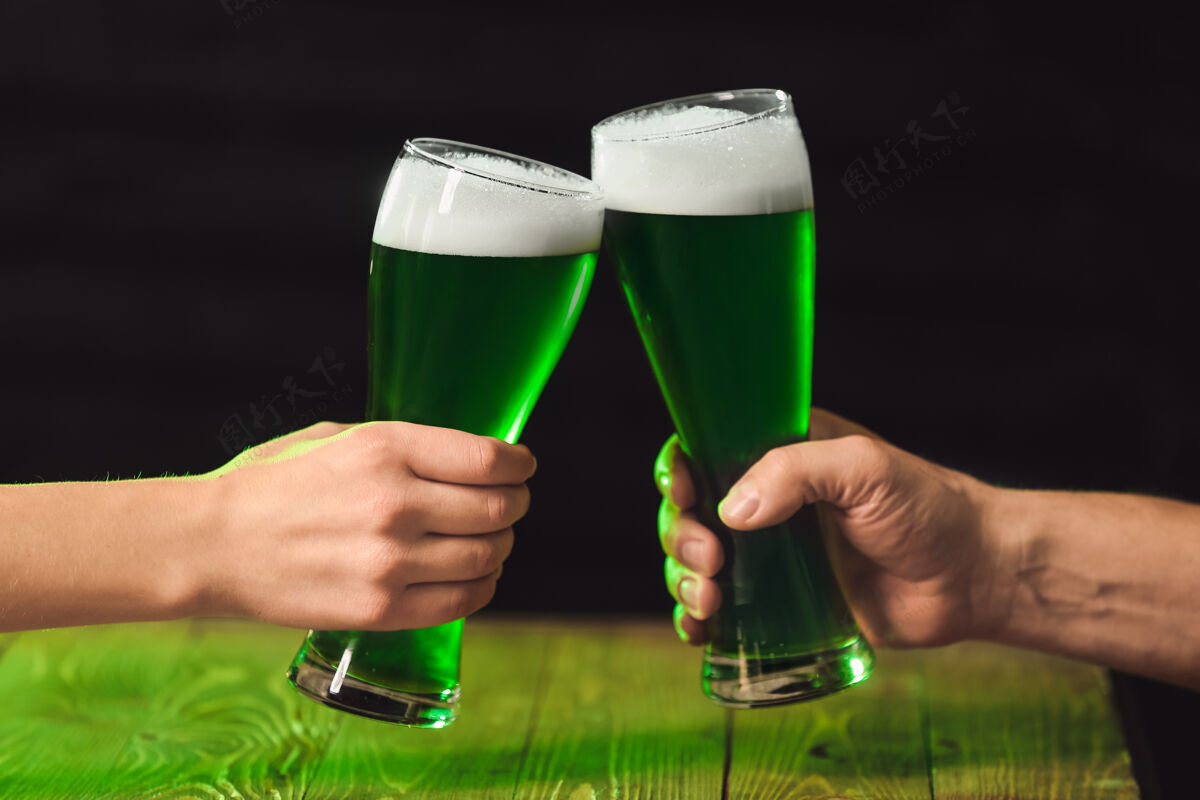 杯子人们在圣帕特里克节在酒吧喝绿啤酒祝酒节日女人