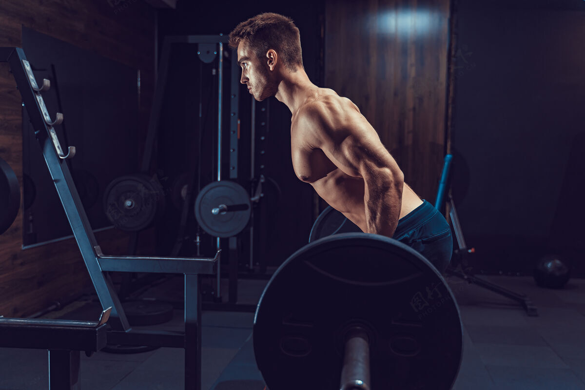 成人为背部做重量级运动的男人痛苦与收获躯干杠铃力量