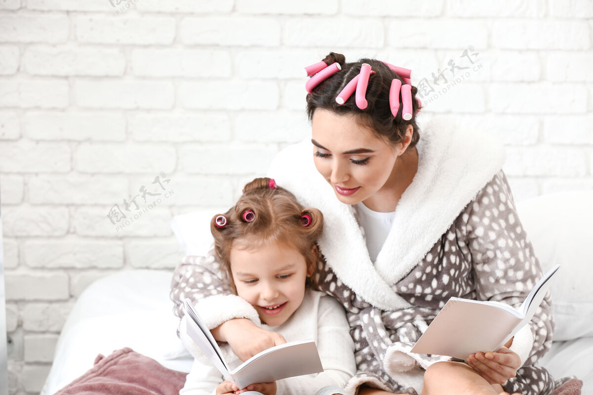 时尚可爱的女儿和妈妈在家卷发笔记本房子孩子