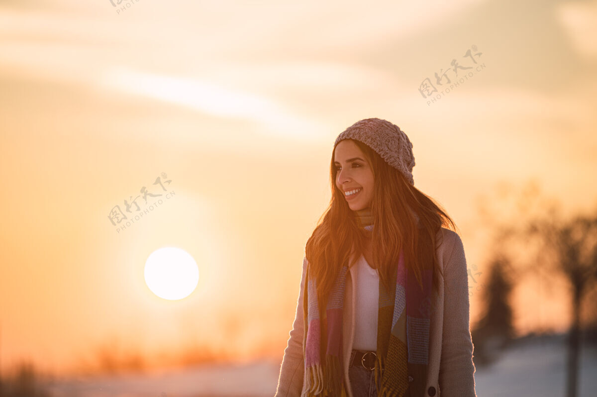 全身夕阳时分 冬日乡间 一身暖洋洋的快乐少女 在新鲜的白雪上漫步远眺独处雪