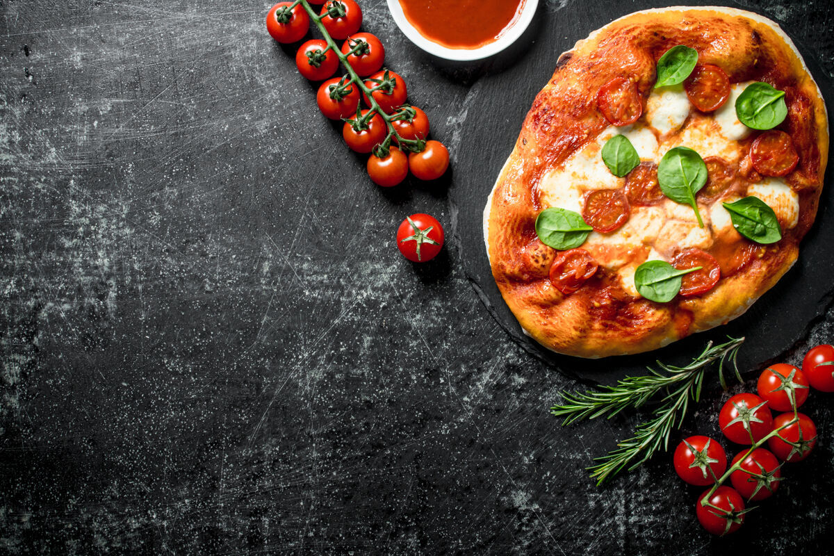 意大利腊肠自制菠菜比萨饼放在深色的乡村餐桌上番茄美味自制