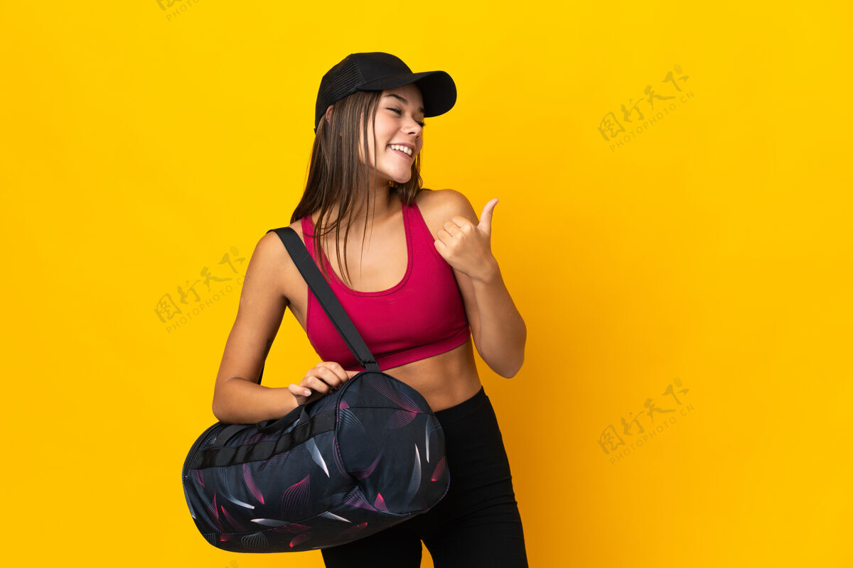 肖像运动女士用运动包指着侧面展示产品信心运动健康