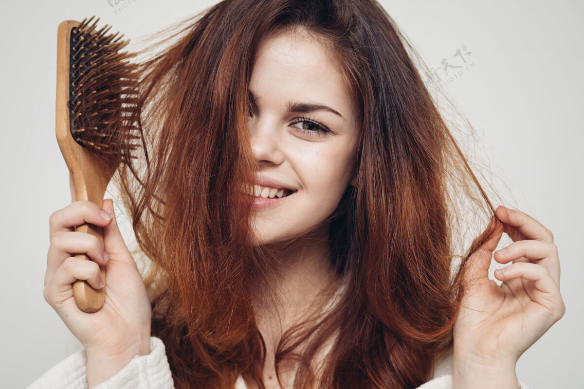 看快乐的女人用发刷梳着轻盈健康的头发洗发水女人沙龙
