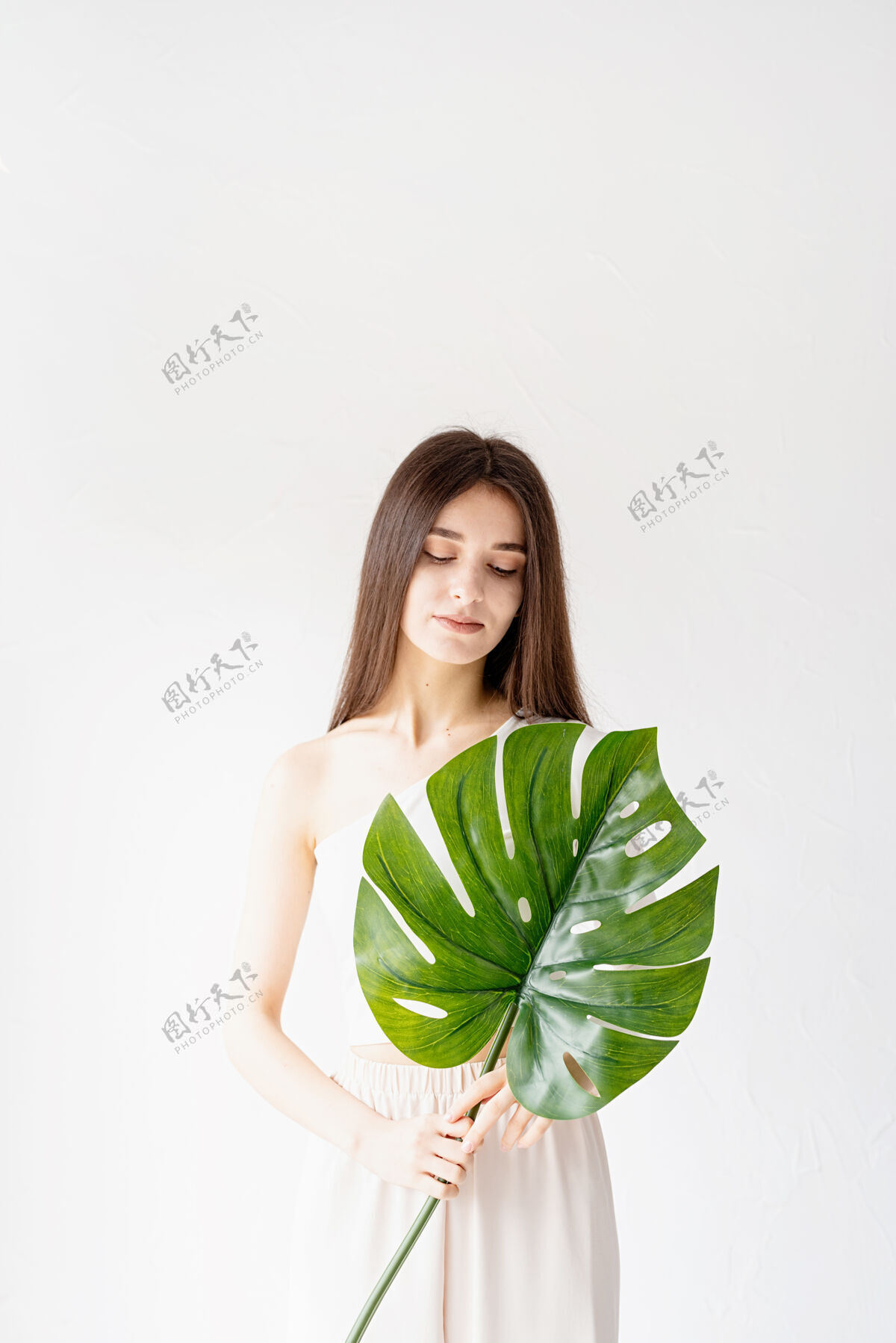 女人水疗和美容自我护理和皮肤护理一个穿着舒适衣服 手持绿叶的快乐美女皮肤化妆品毛巾