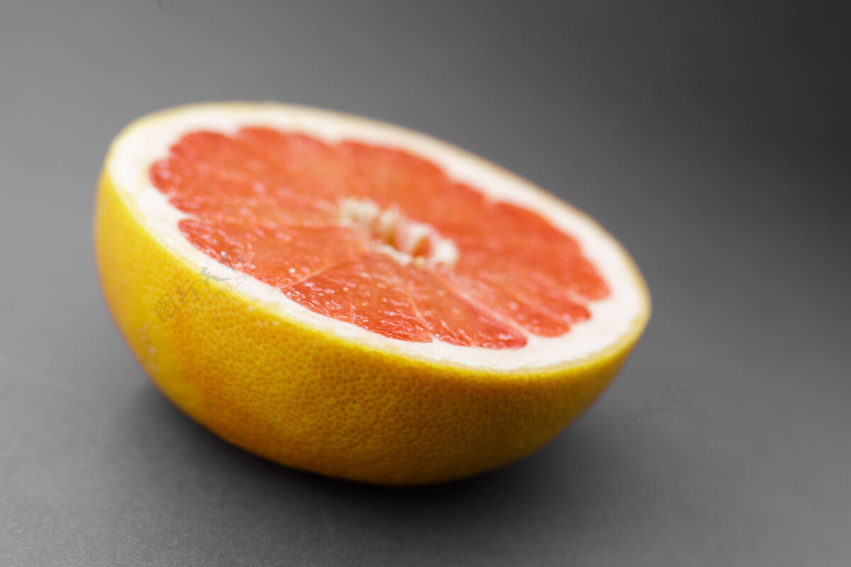 橙色灰色背景上的半个柚子食物团体背景