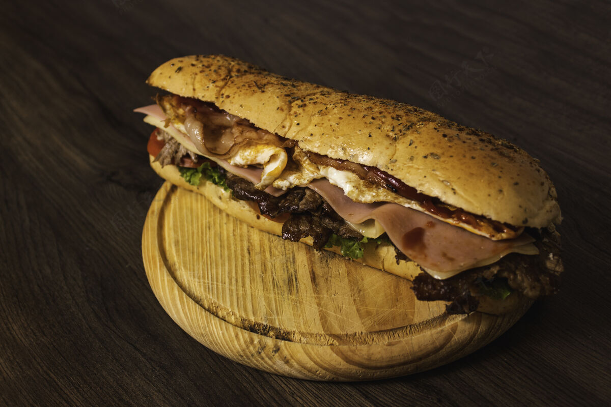 美味一个巨大而美味的里脊三明治放在木盘上一餐洋葱快餐
