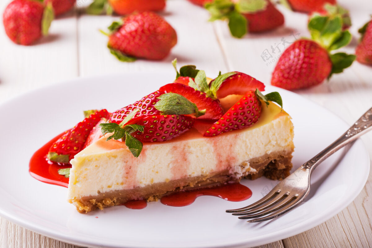 盘子美味的自制芝士蛋糕和草莓放在白色的木桌上糖浆块蛋糕