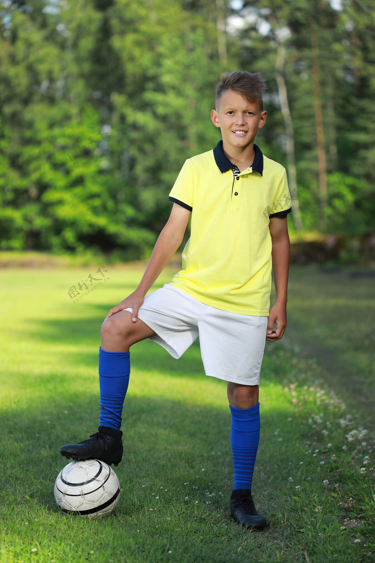 目标一个足球运动员穿着黄色t恤和蓝色紧身裤站在足球场上游戏活跃男性