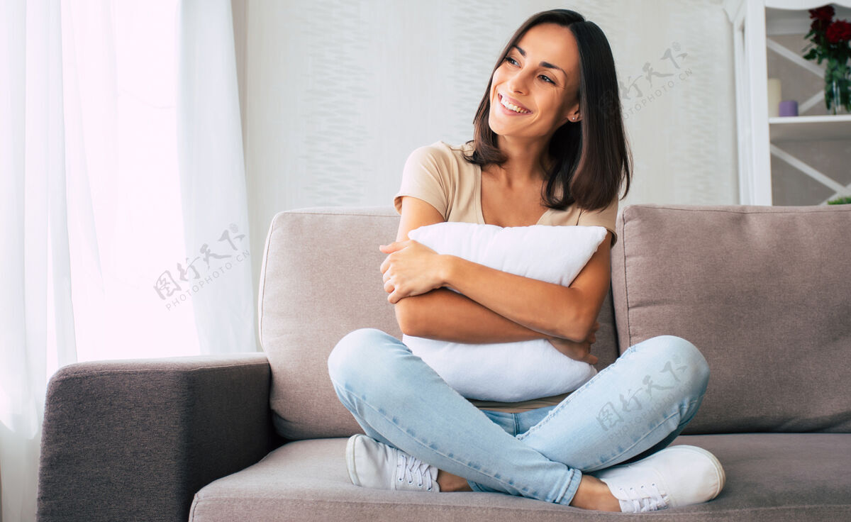 假期美丽的年轻快乐的黑发女人正在家里的沙发上放松和做梦午睡生活方式休息