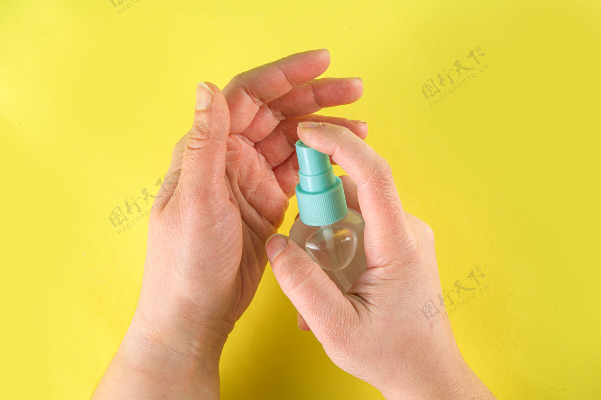 疾病防冠状病毒概念俯视照片的妇女使用防腐剂的手隔离在黄色的墙壁女孩卫生抗病毒