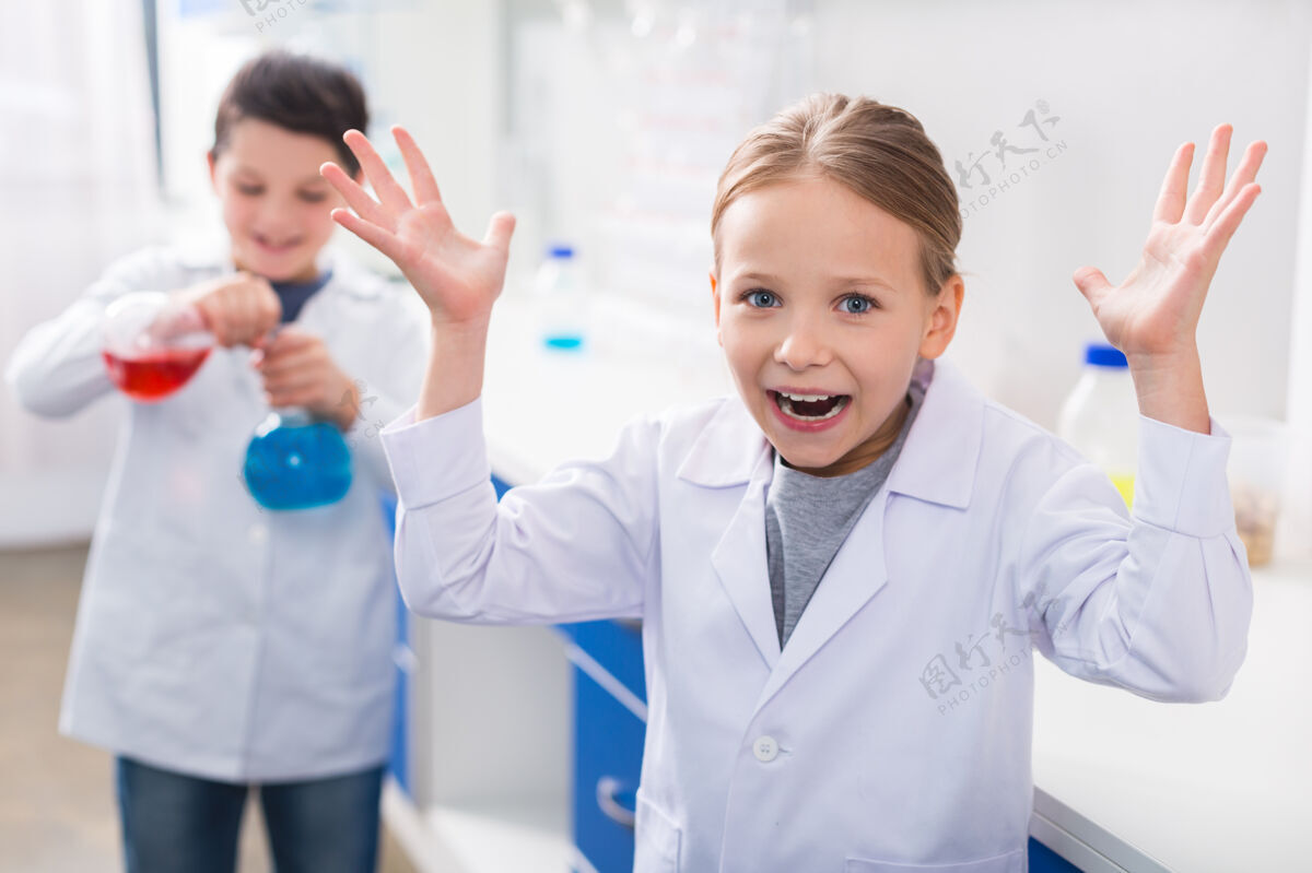 化学做什么积极的情绪可爱的女孩看着你 举起她的手 而不知道该做什么学生生物技术科学家