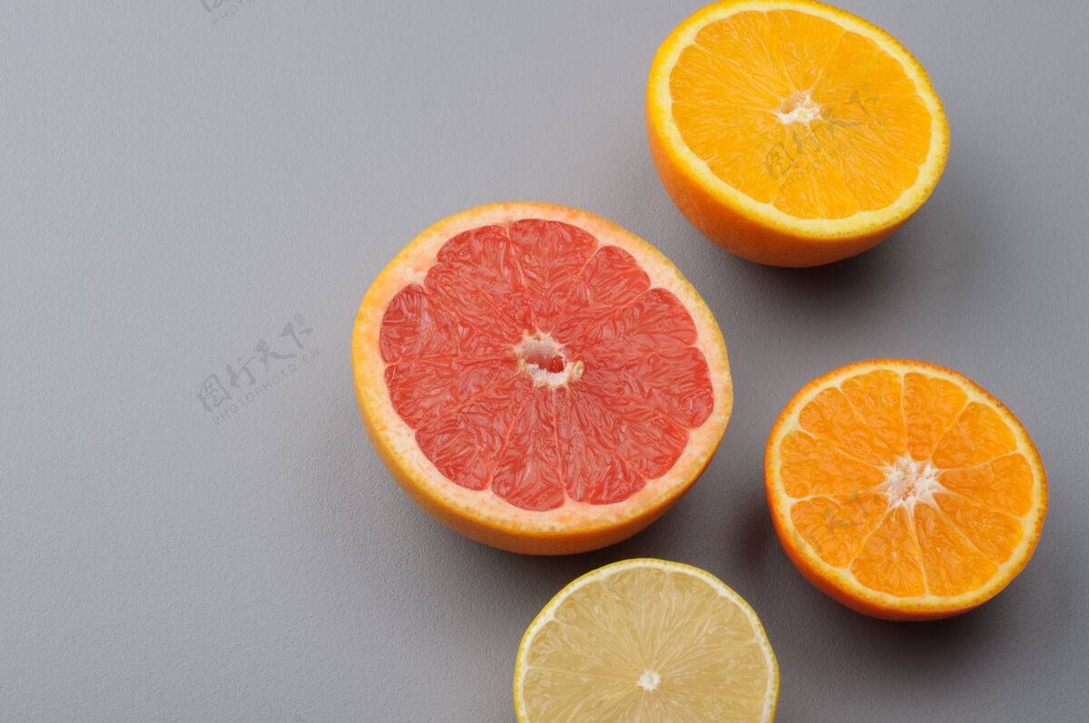 水果切半个新鲜的柠檬 葡萄柚 橘子 橘子在灰色背景上 顶部视图.citrus果汁配料 食品背景食品柠檬新鲜