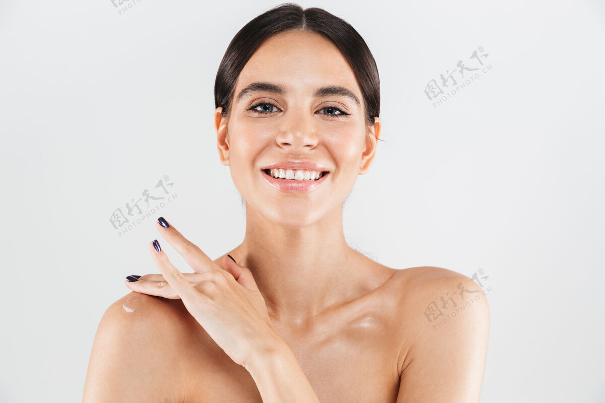 肩膀美丽的肖像一个迷人的健康的女人孤立地站在白色的墙壁 在她的肩膀上涂抹保湿霜治疗应用治疗