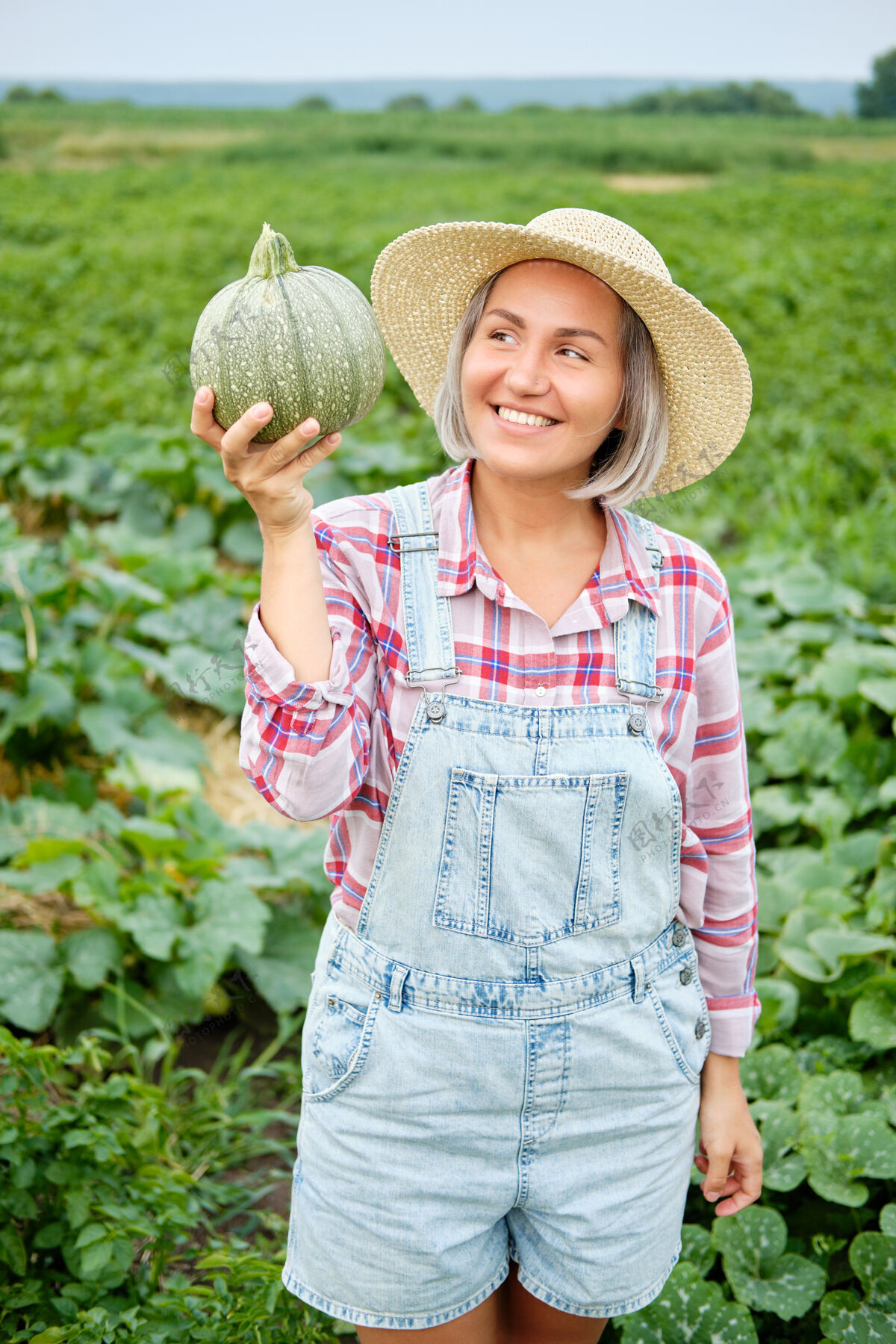 食物在植物上拿着新鲜绿色南瓜的女人田野美丽在阳光明媚的温暖天气里 一个拿着健康蔬菜食品的小女孩站在农场上日间栽培纯素文化有机自然产品吃栽培女性
