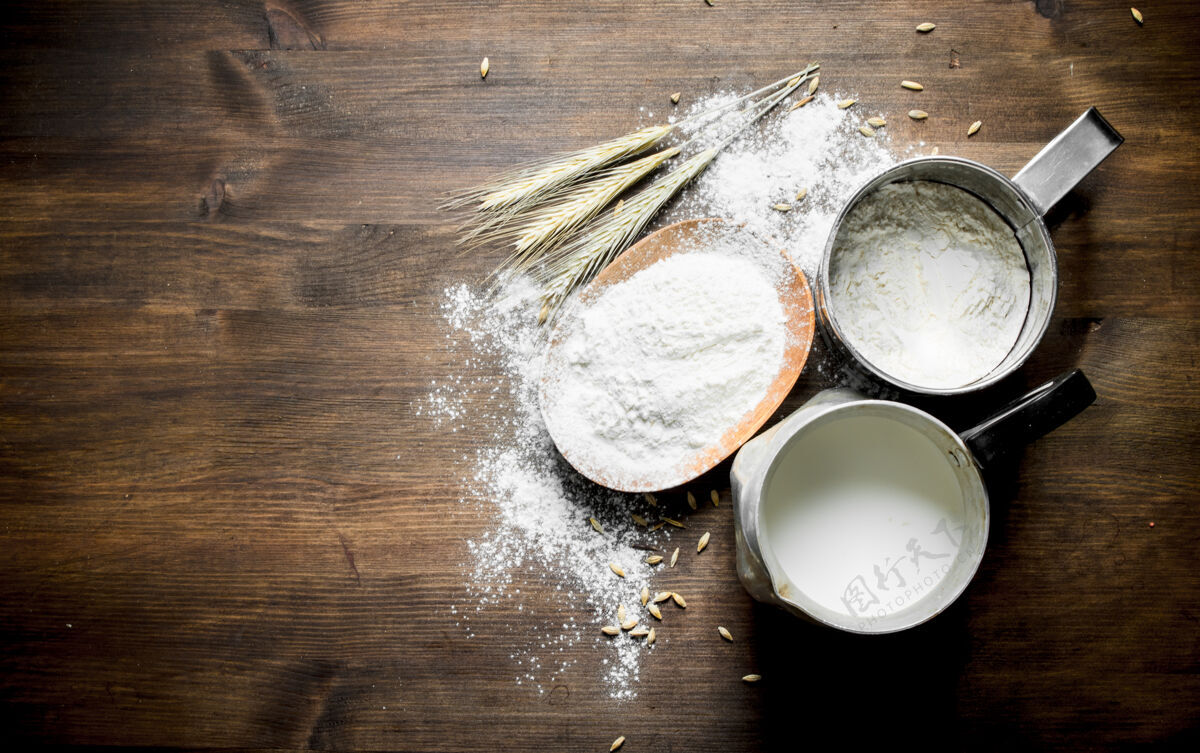 食品面粉和牛奶放在罐子里小穗.on木桌面包房面团玉米