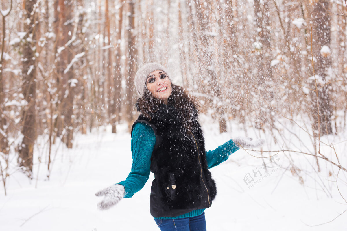 成人时令 休闲 人的理念——年轻女子是快乐的 在冬天自然地抛雪风景点户外