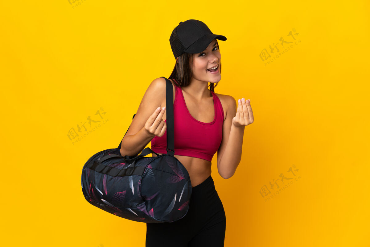 运动员少年运动女孩与运动包赚钱的姿态护理运动帽子