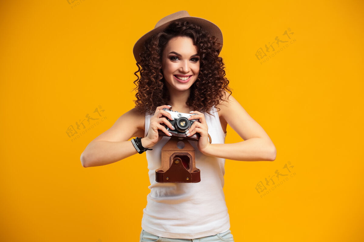 季节在明亮黄色的复古相机上拍摄的笑脸少女肖像笑头发女性