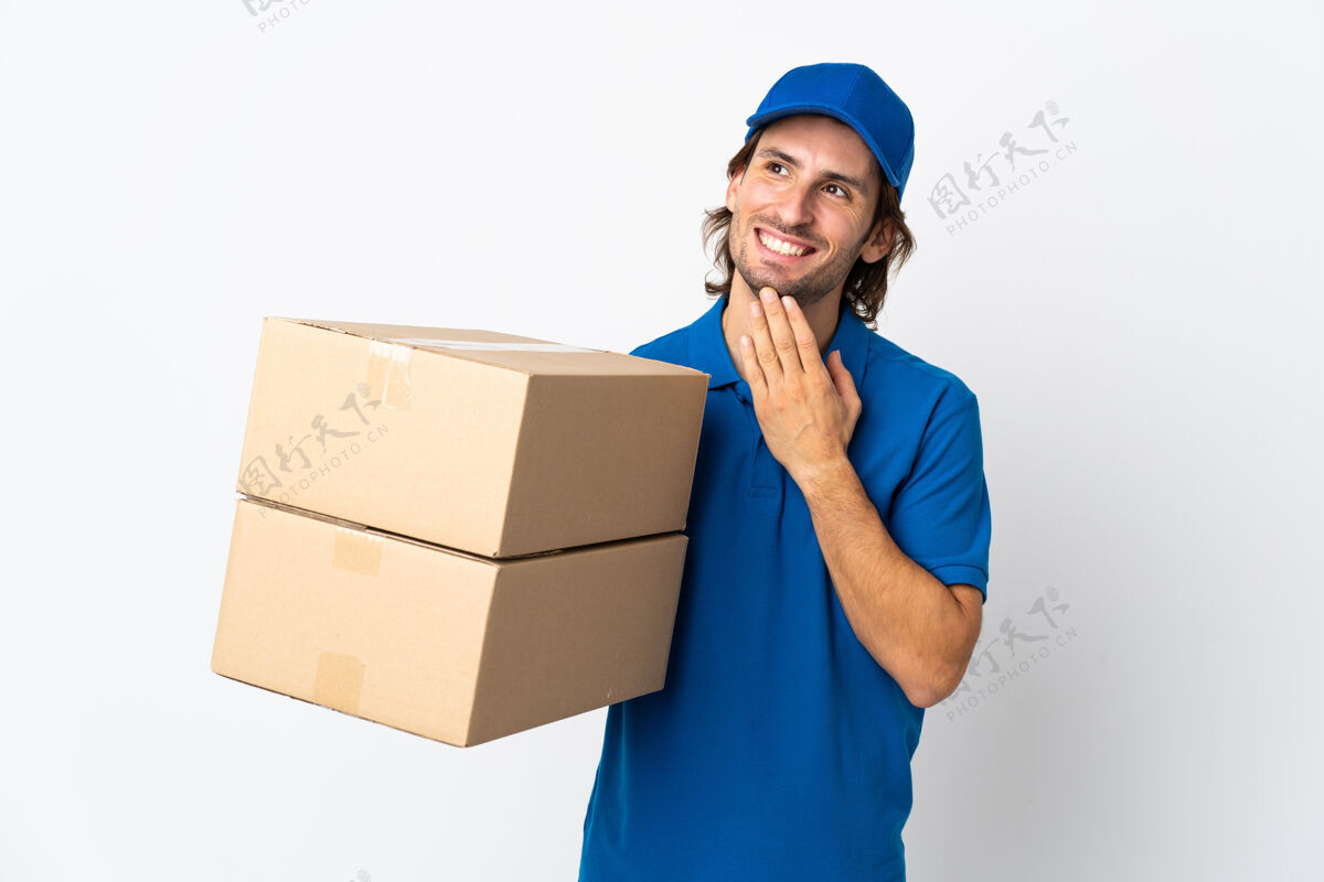 邮政送货员孤零零地站在白墙上微笑着抬头看送货制服思想