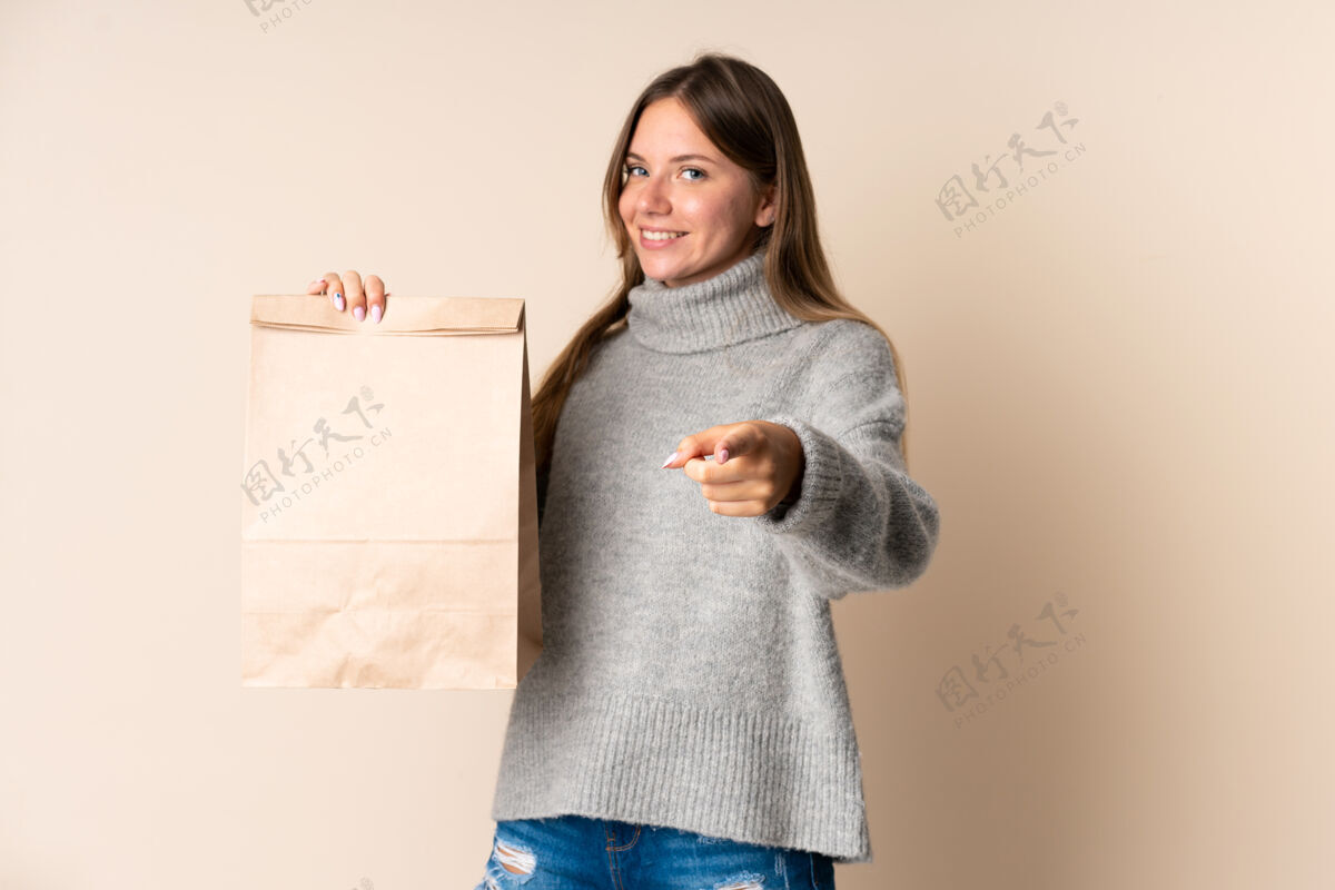 季节立陶宛年轻女子拿着购物袋 用自信的表情指着你积极女性微笑