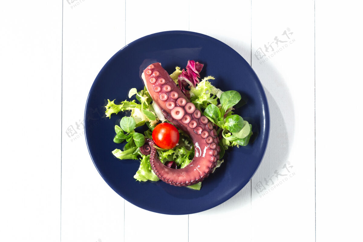顶视图蓝锅炖章鱼触须盘子白色背景顶视图螺旋形海鲜烹饪
