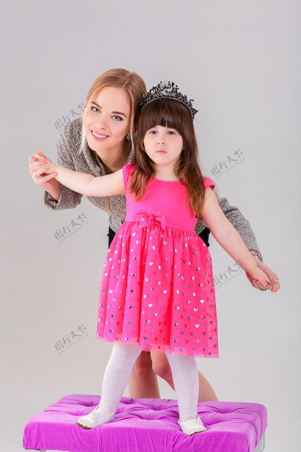 孩子美丽的小女孩穿着粉色公主裙 头戴皇冠 美丽的母亲在灰色背景下拥抱着拥抱微笑女性