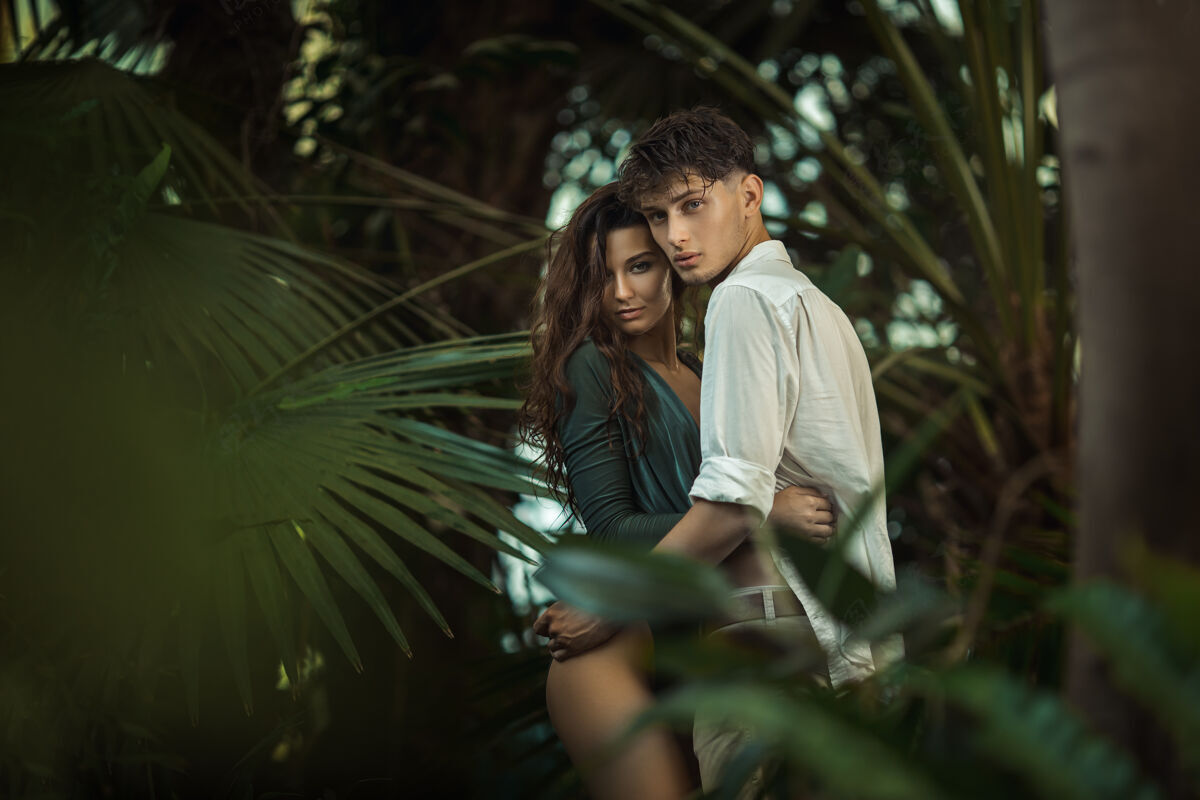 森林一对浪漫的情侣在热带丛林中的异国植物中丛林树叶旅行者
