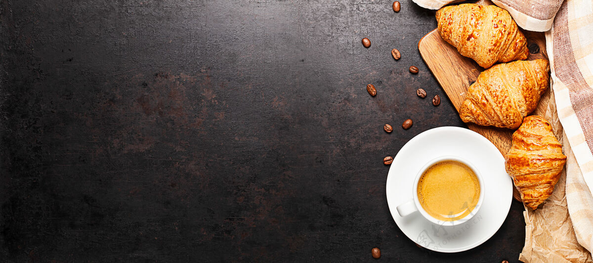 马克杯一杯咖啡和羊角面包站在木板上放在古老的乡村背景上金色早餐新鲜