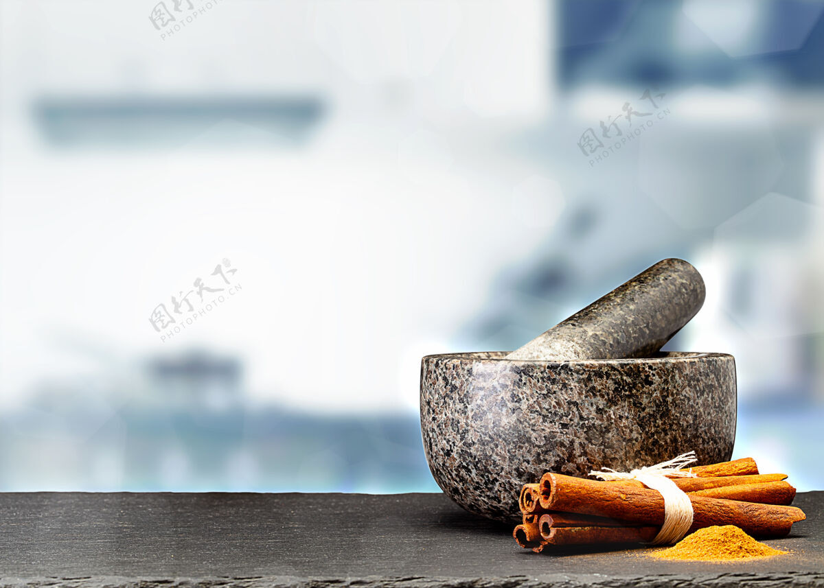 花岗岩在模糊的厨房前面的桌子上放着花岗岩砂浆和香料结香料杵