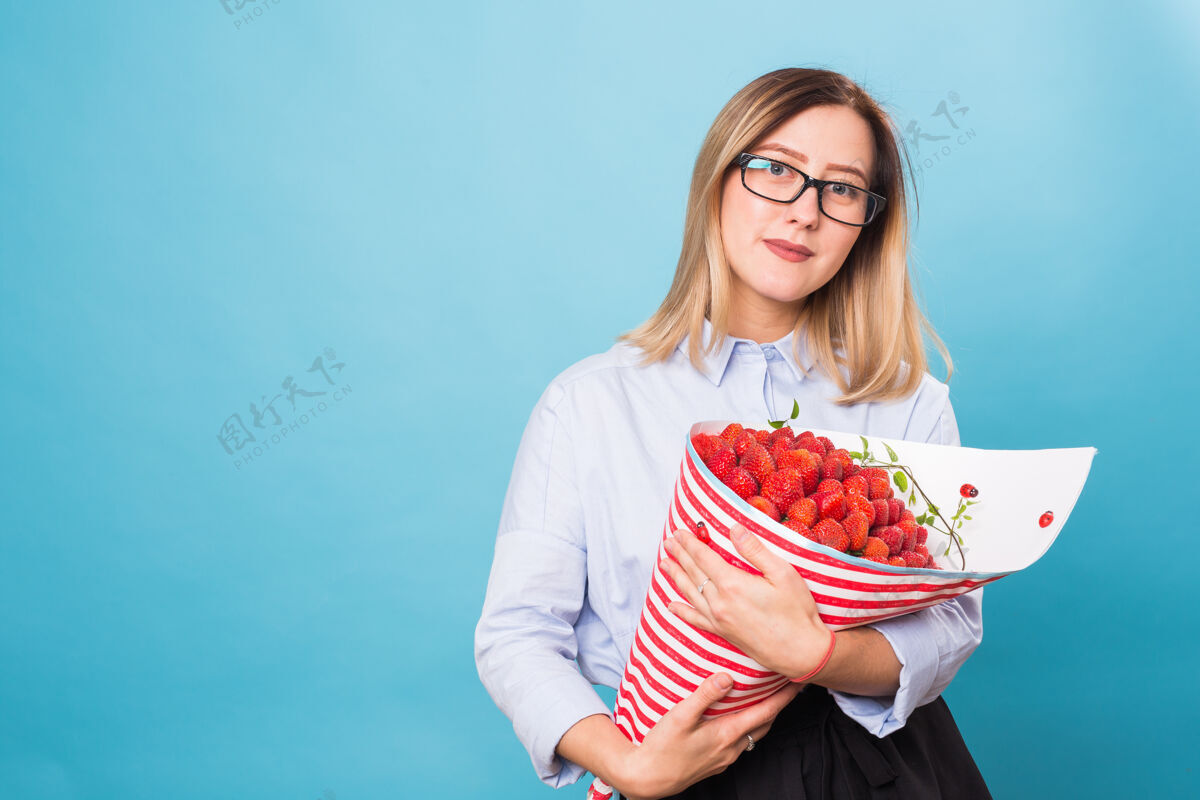 水果拿着一束草莓的年轻女人素食维生素有机