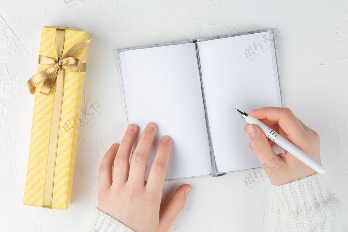 日历女孩的手里拿着一本空白的笔记本框目标计划梦想做清单丝带铅笔天