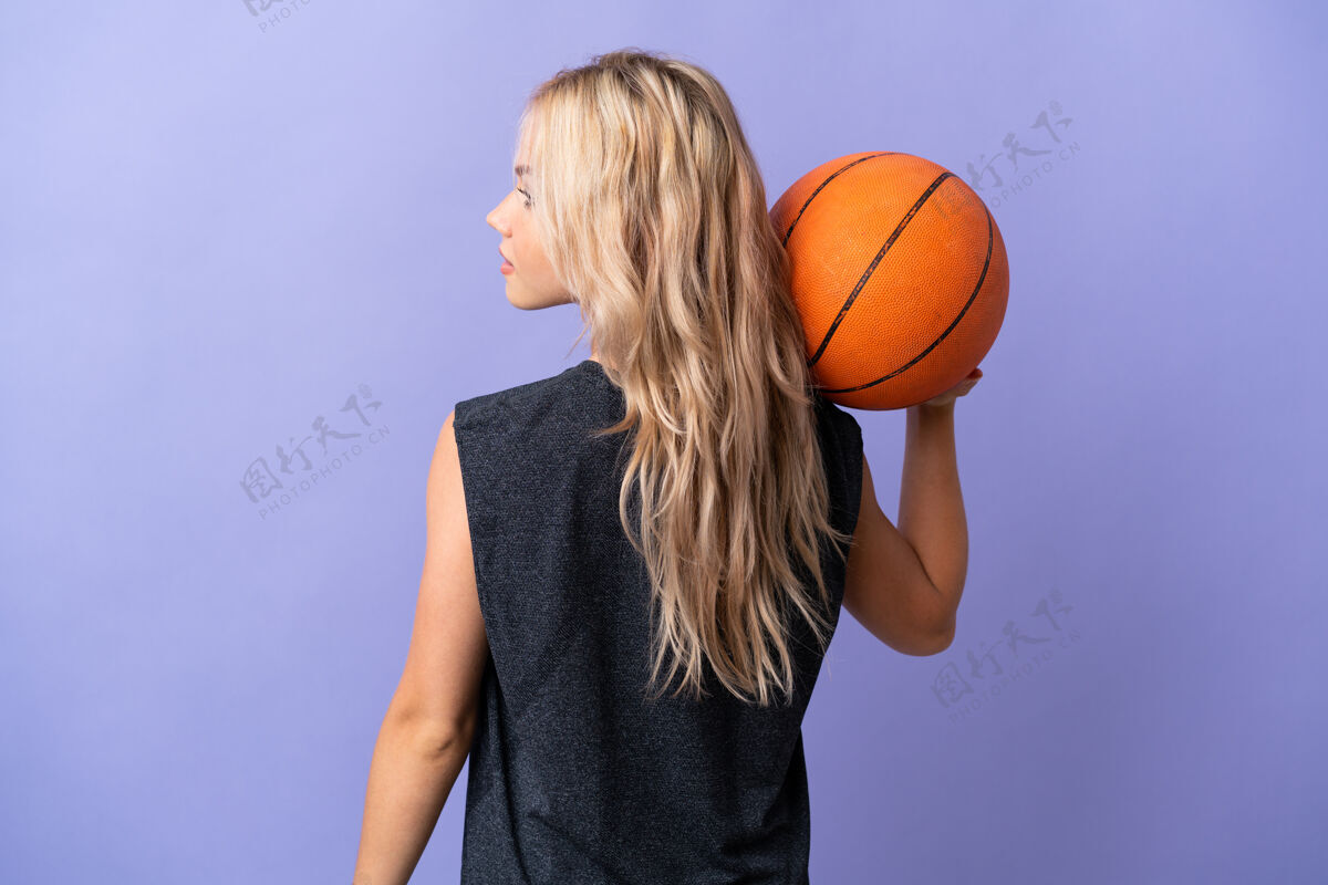 年轻年轻的俄罗斯女子孤身一人在紫色的后座上打篮球位置运动健身