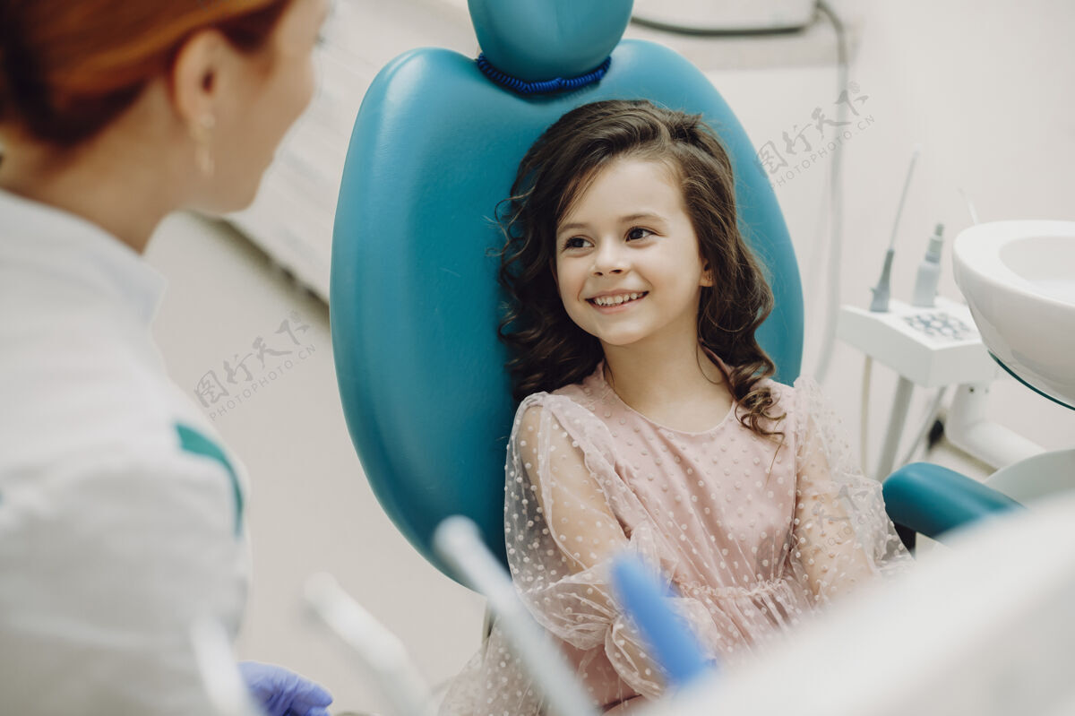 正畸可爱的小女孩微笑着和她的儿科口腔医生交谈 然后做牙齿检查口腔访问微笑