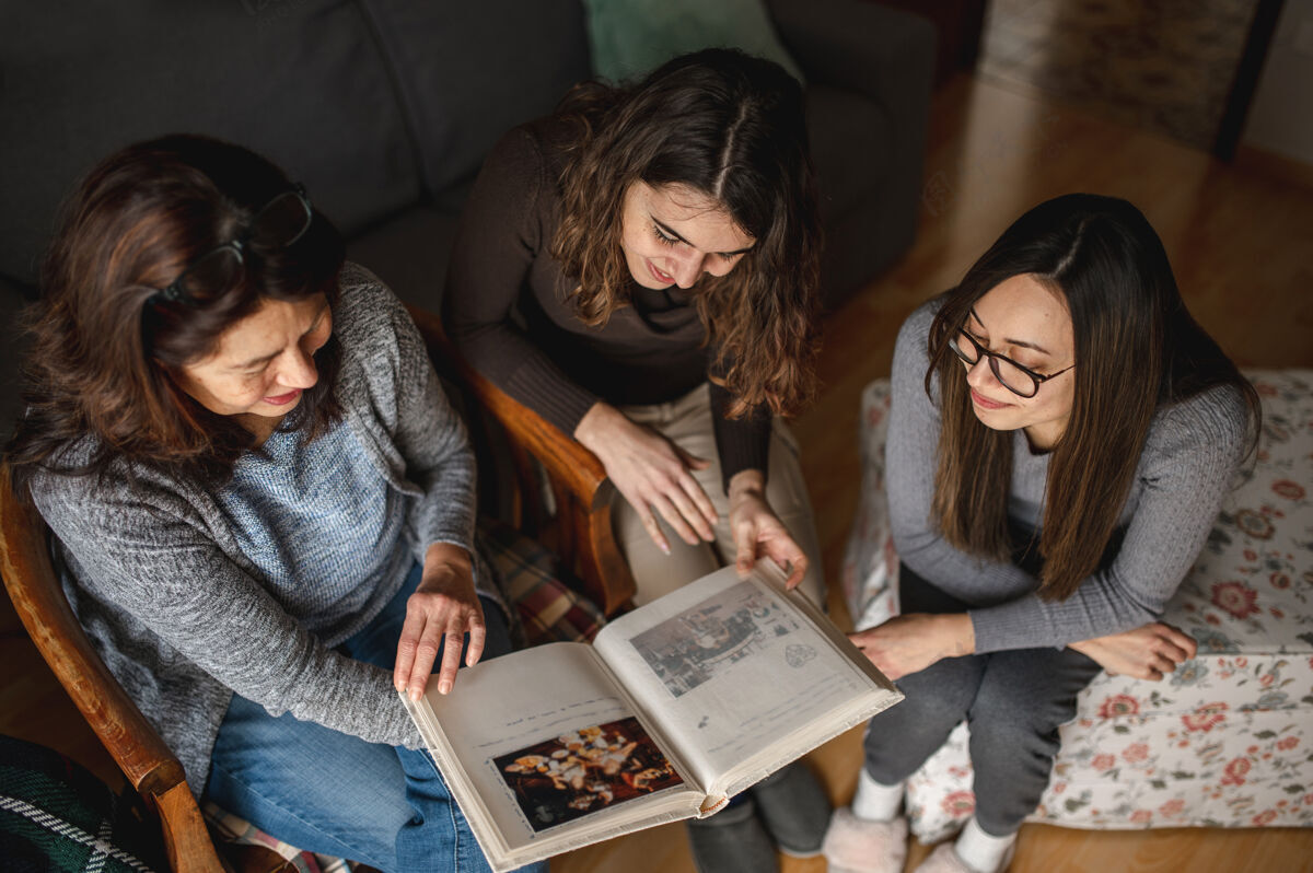 俯视图顶视图三个女人 母女俩在看一本书回忆相聚 家庭观念欢呼女孩团体