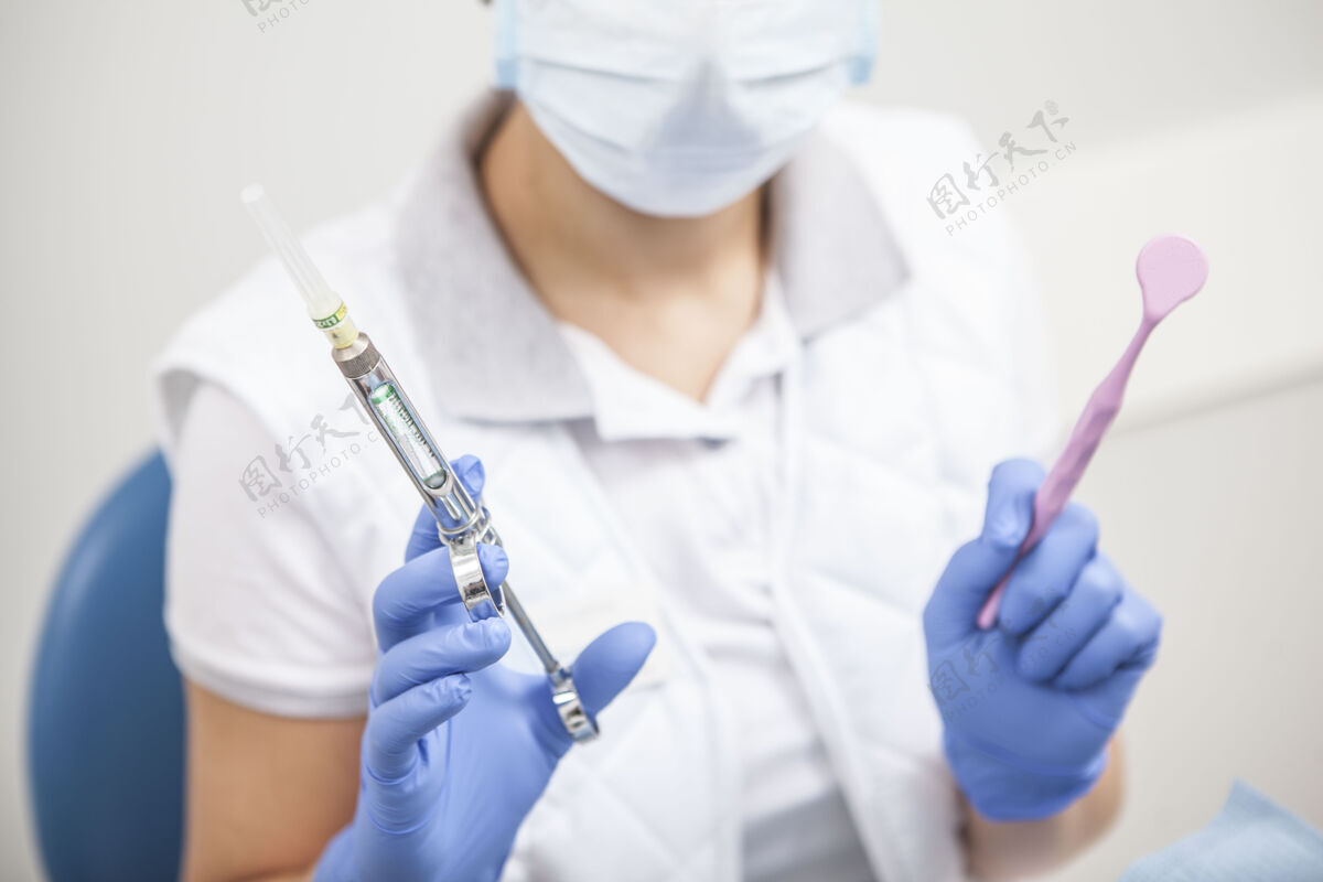护士一张不可辨认的女牙医手持牙科镜和麻醉注射器的剪影手套医学止痛药