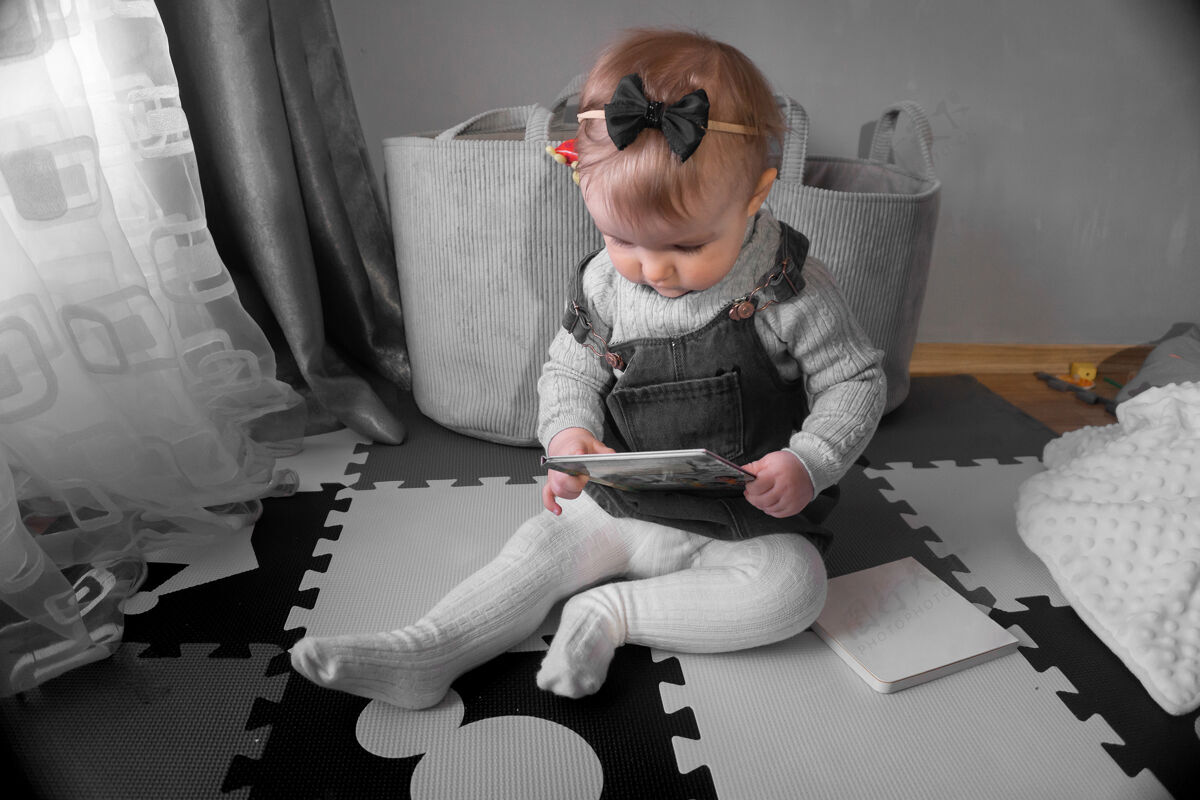 人可爱的小女婴在家看一本书年轻有趣快乐